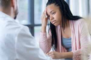 teenage girl listens to physician's migraine treatment plan
