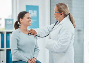 Primary care doctor examining a patient with a stethoscope during a consultation in a clinic
